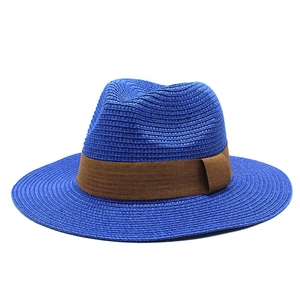 Detail of blue woven panama fedora hat featuring a contrast dark brown ribbon band