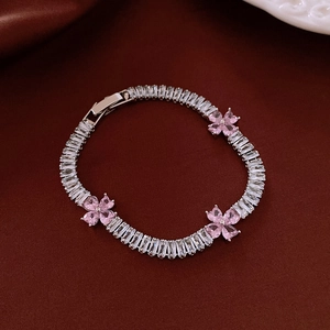Close-up of zircon heart flower bracelet with pink clover crystals on velvet background