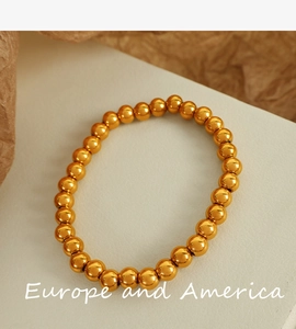 Detail of high-gloss gold stainless steel round beads for minimalist bracelets