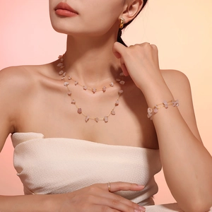 Detail of bohemian jewelry set featuring pink irregular crushed stones and gold chains