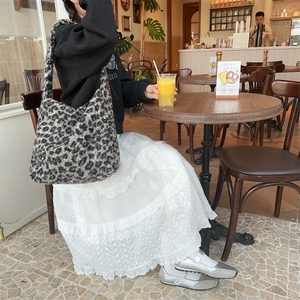 Faux lamb wool leopard print tote bag shown in a cozy cafe lifestyle setting