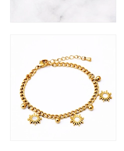 Detailed close-up of golden sun charms and round metal beads on a Cuban chain bracelet