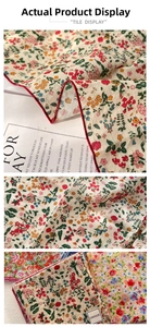 Detail of floral cotton linen square scarf showing red stitched edges and flower pattern
