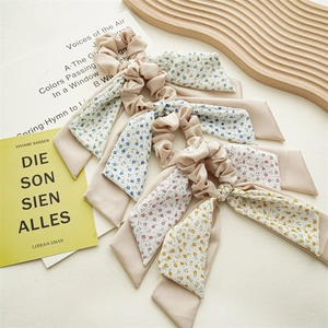 Detailed view of floral bow hair scrunchies on a wooden tray with books