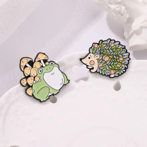 Cute cartoon enamel pins featuring green frog with mushrooms and floral hedgehog designs