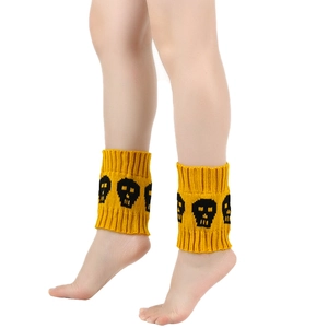 Detailed close-up of yellow knitted boot cuffs featuring black skull patterns