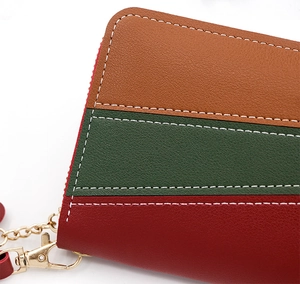 Close-up of tricolor leather wallet featuring precise white stitching and gold hardware