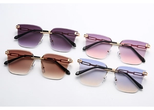 Flat lay of rimless gradient sunglasses in purple, pink, brown and blue yellow tint