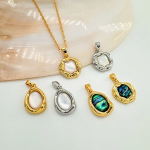 Macro shot of 18K gold plated oval abalone shell pendants with natural iridescent luster