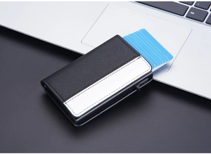Detail view of carbon fiber RFID card holder with automatic pop-up lever on laptop surface