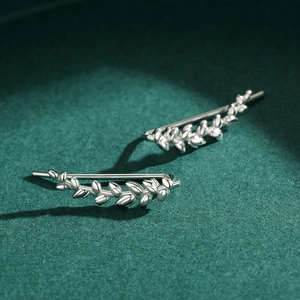 Minimalist S925 sterling silver leaf ear crawlers with polished finish on green surface
