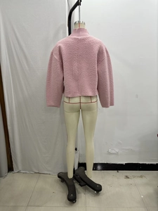 Detail view of pink sherpa fleece jacket texture with loose fit and stand collar