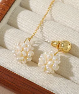 Detail showing natural freshwater pearl cluster earrings with elegant gold chain dangle