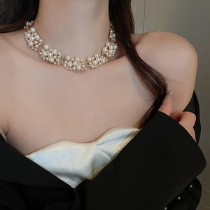 Detail of layered gold pearl necklace with rhinestone accents on a model in satin dress