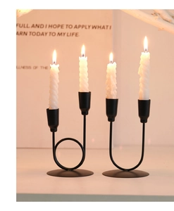 Détail de bougeoirs minimalistes en fer noir avec bougies en spirale blanches