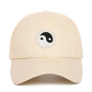 Detailed view of Yin Yang Tai Chi embroidery on a beige cotton baseball cap with stitching