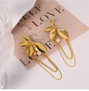 Detail view of gold flower earrings with pearl accents and chain tassels on a card