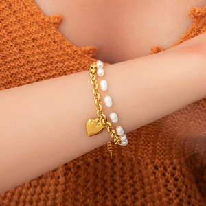 Détail d'un bracelet double couche plaqué or 18 carats avec pendentif cœur et perles