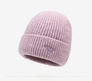 Detail of lavender knit beanie with purple letter embroidery and ribbed texture