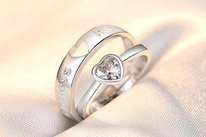 Detailed view of silver couple rings with heart zircon and endless love engraving