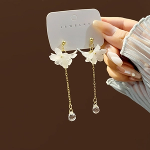 Elegant white floral tassel earrings with gold chain and clear crystal drops on jewelry card