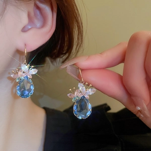 Elegant gold drop earrings with blue zircon butterflies and sparkling crystal accents