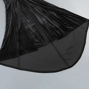 Gros plan détaillé de l'ourlet de la jupe en velours noir montrant texture et reflet