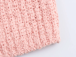 Close-up of pink knit tank top featuring textured organza bow detail and premium stitching