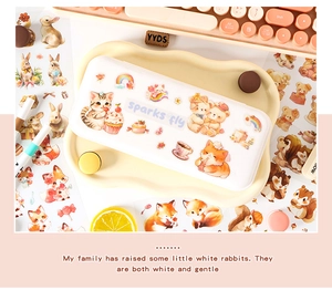Detailed view of cute cartoon animal stickers and cream stationery storage box on desk
