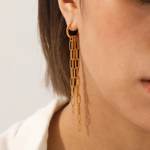 Boucles d'oreilles longues à pampilles en acier inoxydable doré 18 carats sur modèle