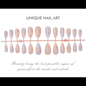 Macro view of almond shaped press-on nails with silver snowflakes and rhinestones