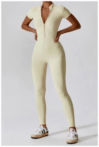Detail shot of cream short sleeve yoga jumpsuit featuring a functional front zipper design