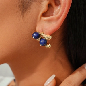 Detailed view of vintage gold textured earrings featuring deep blue lapis lazuli beads