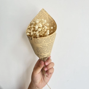 Mini dried gypsophila bouquet wrapped in vintage newspaper paper with hemp rope tie