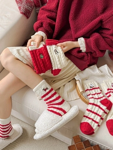 Detail of Christmas fuzzy socks with festive embroidery and thick warm coral fleece texture