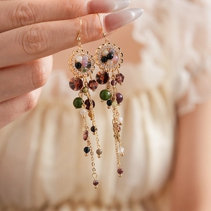 Detail of vintage long tassel earrings with colorful beads and floral gold metal charm