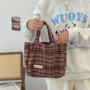 Close-up of vintage plaid tote bag with colorful checkered pattern and woven fabric texture