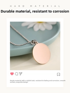 Detailed close-up of a smooth rose gold round metal pendant with a ball chain necklace