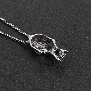 Vintage silver skull pendant necklace with gothic punk style on black textured surface