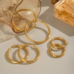 Three pairs of gold minimalist stainless steel hoop earrings in small, medium, and large sizes