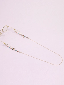 Detail of gold evil eye glasses chain with colorful charms and silicone ends
