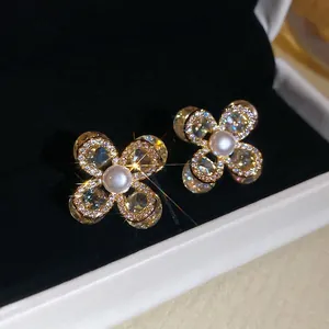 Boucles d'oreilles trèfle dorées élégantes avec pétales en zircon et perle centrale