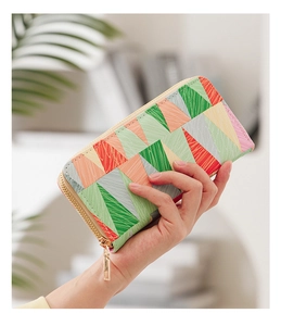 Detail of colorful geometric triangle pattern on a textured long wallet with gold zipper