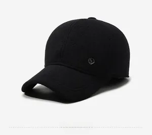Detail of a black winter baseball cap showing the thick wool fabric and silver metal shield logo