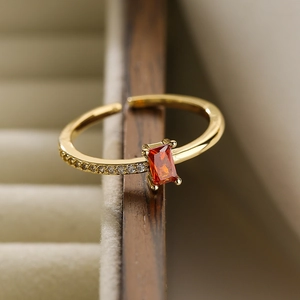 Macro shot of 18K gold plated adjustable ring featuring a rectangular ruby zircon setting
