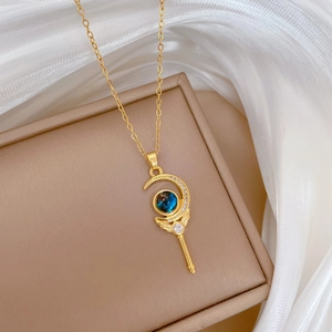 Golden moon wand pendant necklace with blue gemstone and diamonds on jewelry box