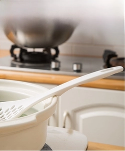 Detail of white nylon skimmer spoon featuring a heat-resistant handle with non-slip support