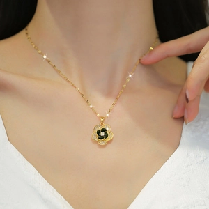 Elegant gold flower necklace with black enamel petals and shimmering zircon stones