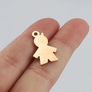 Close-up of small rose gold boy-shaped charm pendant held by hand for size reference