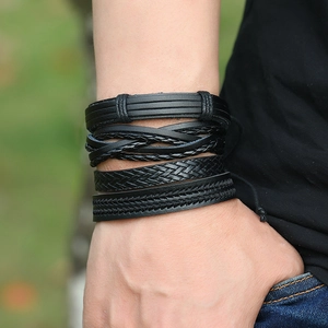 Close-up of black multilayer braided leather bracelets set worn on a wrist